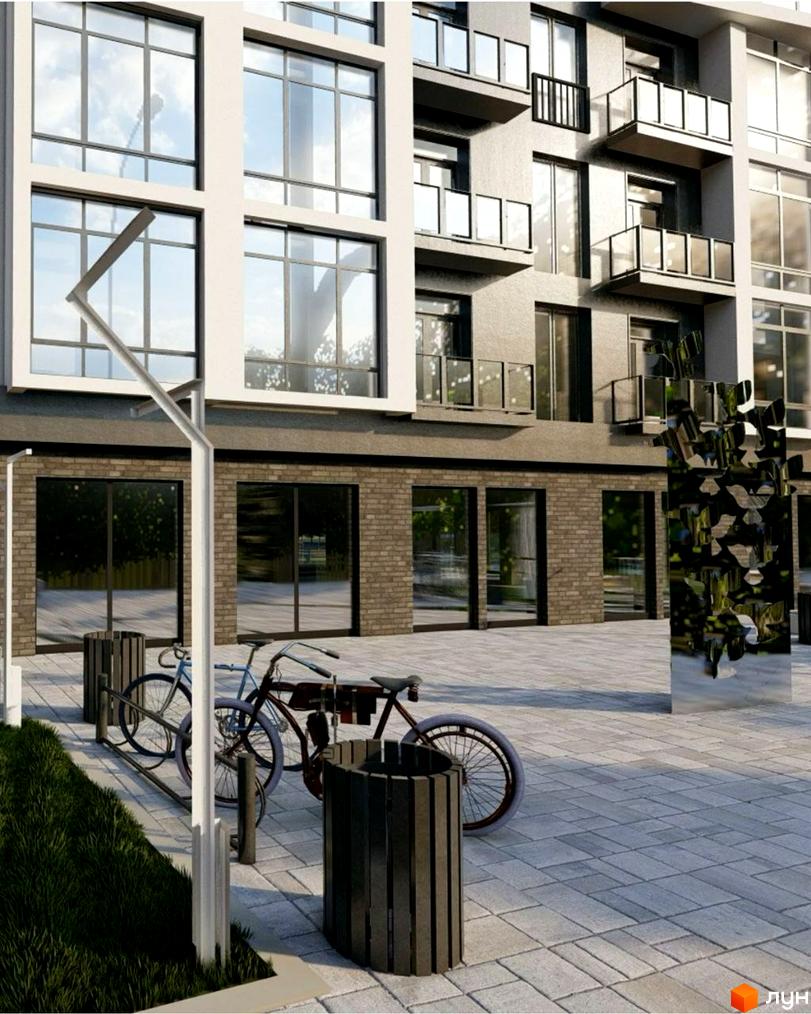 Фасад Житлового комплексу Сонячна Долина з великими вікнами, балконами та цегляним цоколем. Прибудинкова територія з бруківкою, велосипедами та урнами.