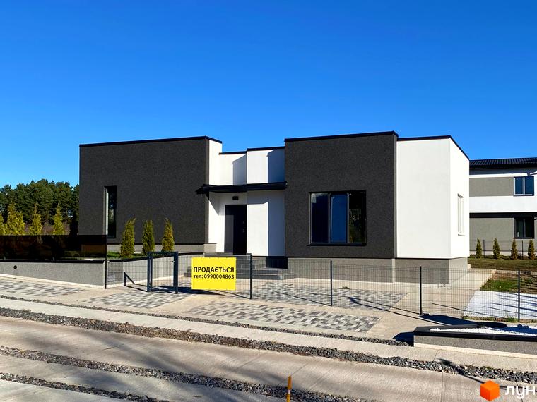 Сучасний двоповерховий будинок у світлих та темних тонах з великими вікнами. Перед будинком розташована огорожа та доріжка з бруківки.