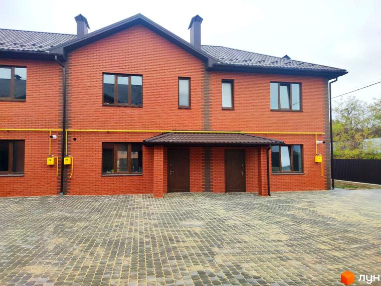 Зовнішній вигляд цегляного будинку в Котеджному містечку Екологічне. Подвір'я вимощене тротуарною плиткою.