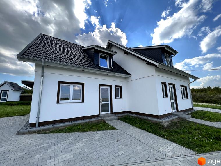 Котеджне містечко MEINDORF: білий двоповерховий будинок з темним дахом та вікнами, вимощені доріжки та зелена прибудинкова територія.