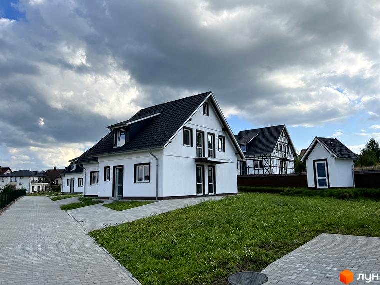 Котеджне містечко MEINDORF: білі двоповерхові будинки з темними дахами, огороджена територія з газоном та бруківкою.