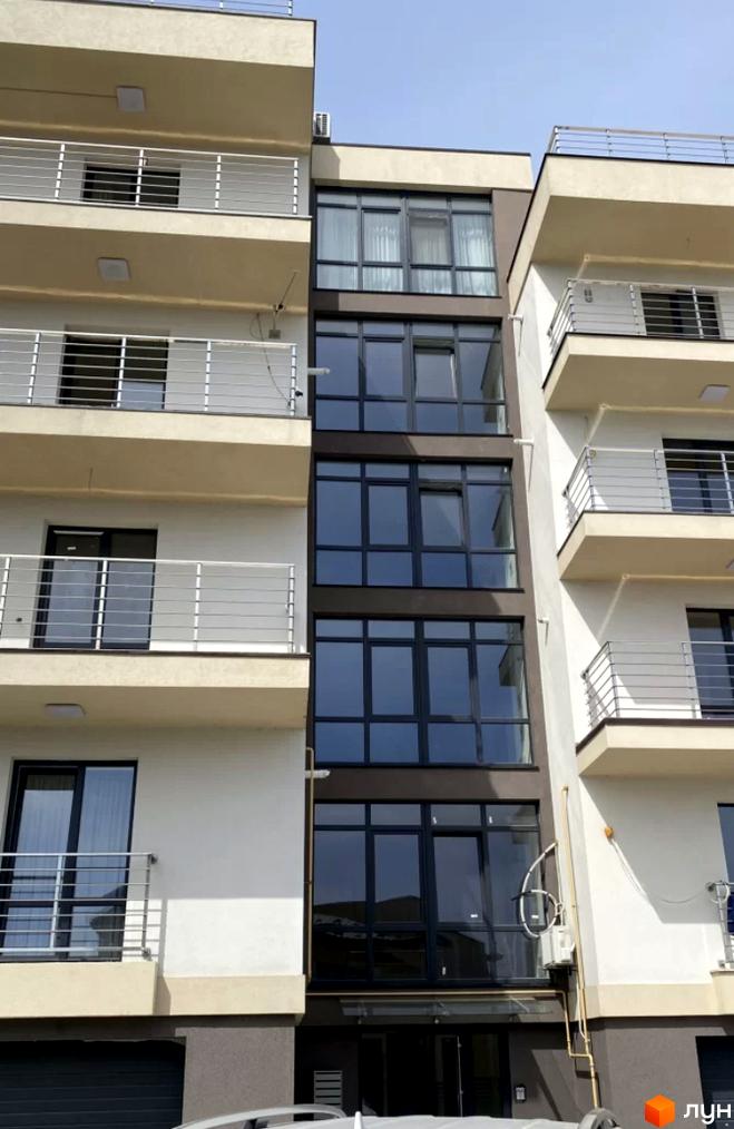 Фасад новобудови ЖК Беладжіо з балконами та великими вікнами. Зовнішній вигляд будинку з сучасними елементами.