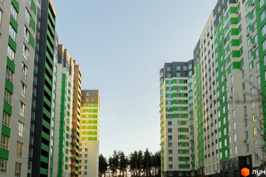 Новобудова ЖК City Park з яскравим зеленим фасадом та великою кількістю вікон. Сучасні багатоповерхові будинки на фоні ясного неба.