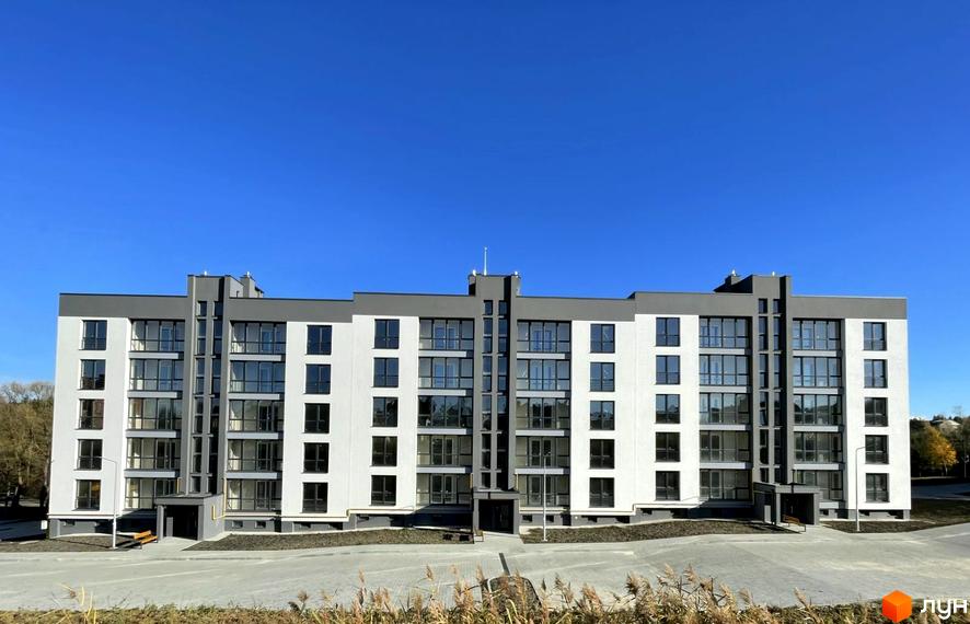 Сучасний житловий комплекс Baker Street з біло-сірими фасадами та великими вікнами. Перед будинком облаштований простір з доріжками та зеленими насадженнями.