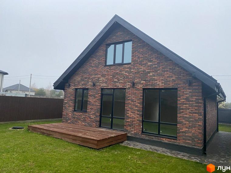 Котеджне містечко КМ Одноповерховий Київ - Віта-Поштова. Будинок з цегляним фасадом та дерев'яною терасою на зеленій ділянці.