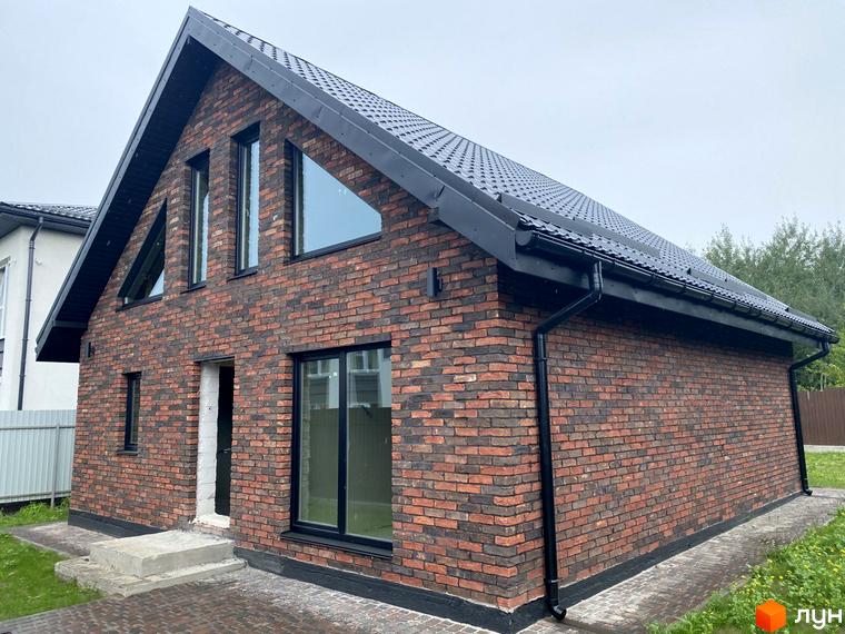 Котеджне містечко КМ Одноповерховий Київ - Віта-Поштова: одноповерховий будинок з червоної цегли з чорним дахом та вікнами, поруч бруківка та зелена трава.