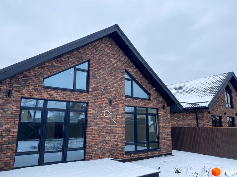 Котеджне містечко КМ Приморська Баварія: цегляні будинки з великими вікнами та темним дахом, на тлі сірого неба та засніженої території.