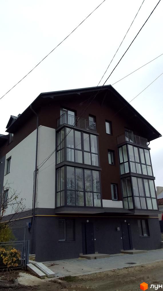 Зовнішній вигляд новобудови на вулиці Чернівецька, 17, з великими панорамними вікнами та балконами. Прибудинкова територія з елементами благоустрою.