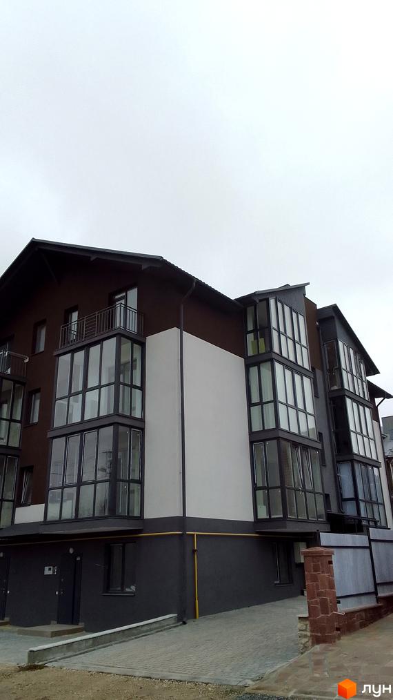 Зовнішній вигляд новобудови на вулиці Чернівецькій, 17. Будинок має коричневий фасад та великі панорамні вікна.