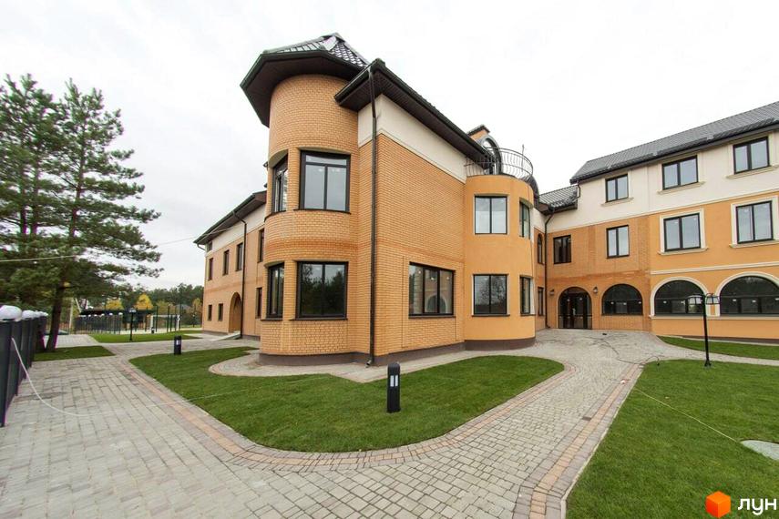 Зовнішній вигляд новобудови ЖК Мюнхен з цегляним фасадом та прибудинковою територією з доріжками та газоном.