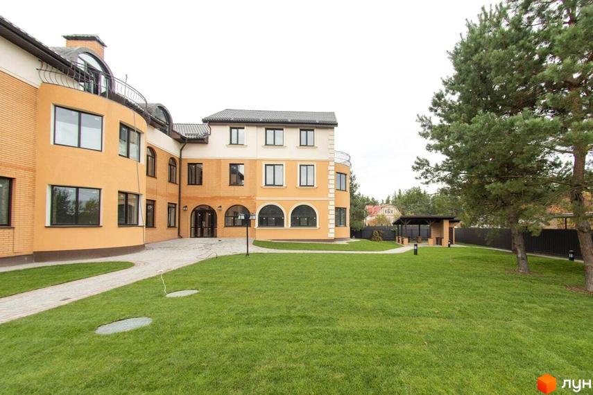 Житловий комплекс Мюнхен: фасади будівель з цегляним оздобленням та великими вікнами, доглянута прибудинкова територія з газоном та деревами.