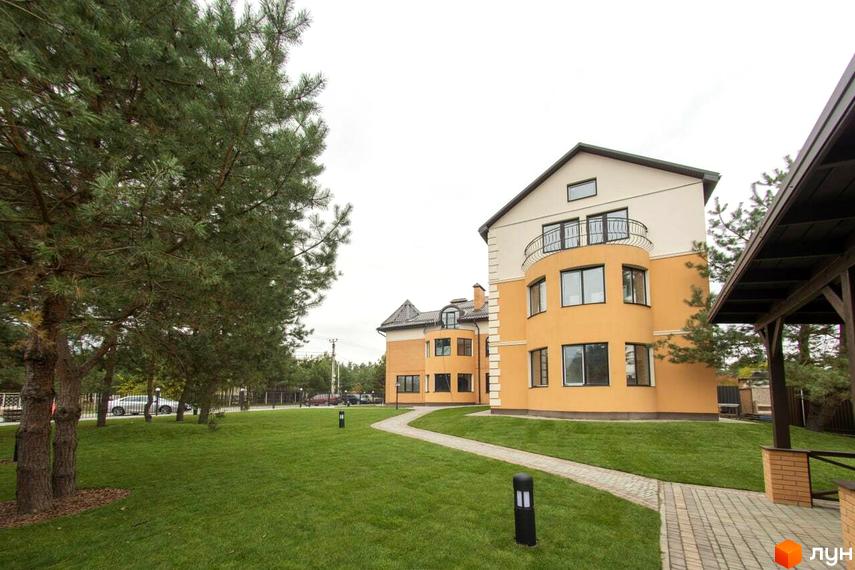 Житловий комплекс Мюнхен – двоповерхові будинки з жовтою обробкою та балконами, оточені доглянутим газоном та доріжками.