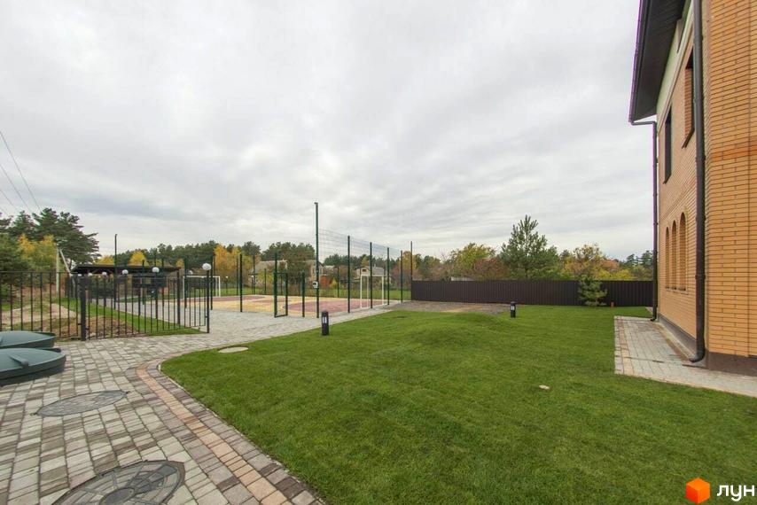 Будинок ЖК Мюнхен із цегляним фасадом та прибудинковою територією з газоном та спортивним майданчиком.