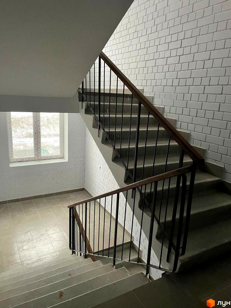 Сходи в новобудові ЖК на Масанах з білими цегляними стінами та вікном. Сучасний дизайн сходової клітки.