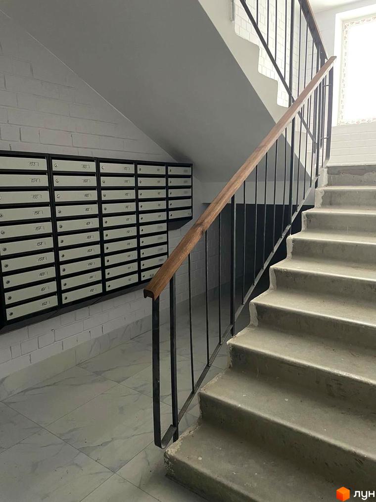 Новобудова ЖК на Масанах. Вхідна група з поштовими скриньками та сходовим маршем з дерев'яним поручнем.
