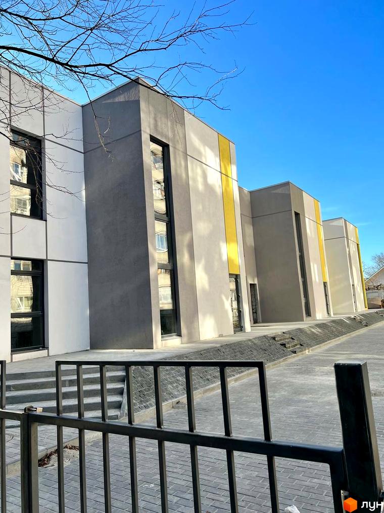 Зображення фасаду Будівельного проєкту ART HOUSE з великими вікнами та прибудинковою територією. Вигляд з вулиці.