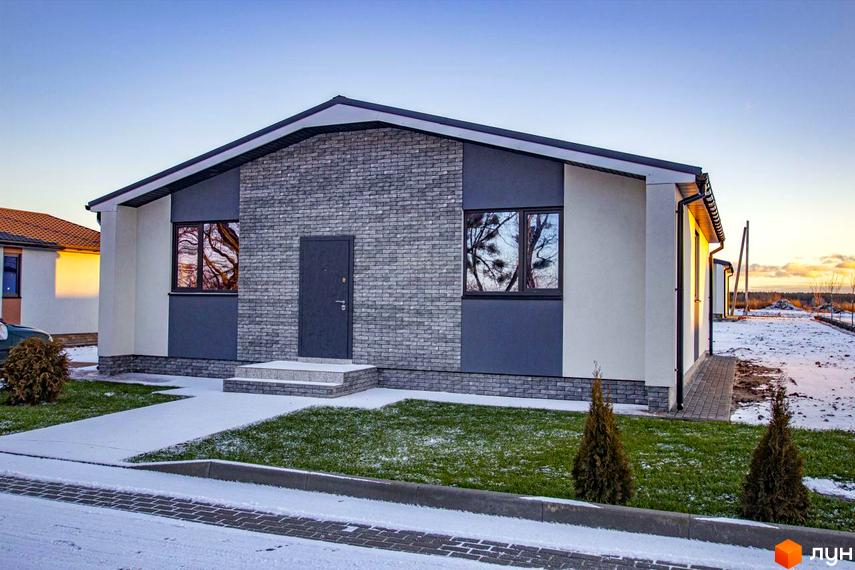 Котеджне містечко Мілленіум: одноповерховий будинок з сірою цегляною фасадною частиною та великими вікнами на тлі зимового пейзажу. Навколо будинку доглянутий газон та доріжки.