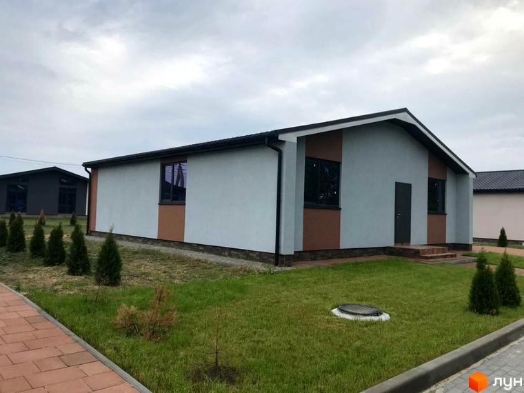 Зовнішній вигляд будинку КМ Мілленіум з сірим фасадом та коричневими вставками, охайний двір з зеленим газоном та туями. Котеджне містечко для комфортного життя.