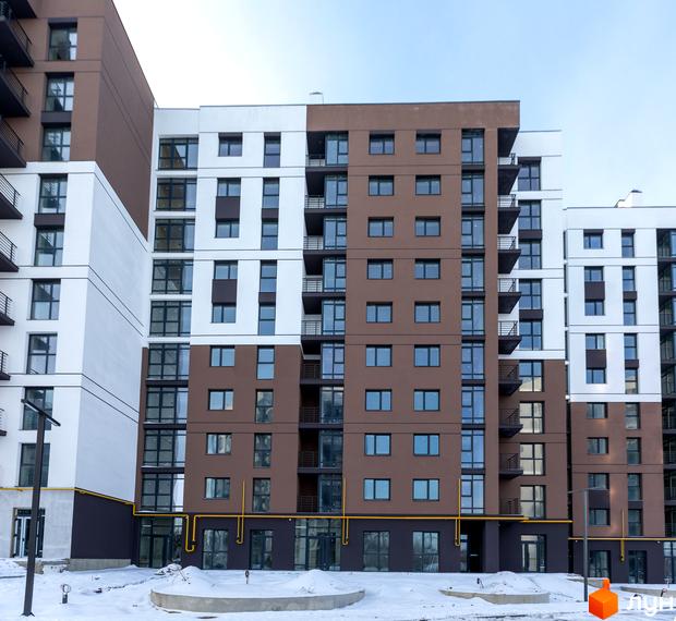Новобудова ЖК Супернова з коричнево-білими фасадами та балконами. Навколо будівлі видно засніжену територію та елементи благоустрою.