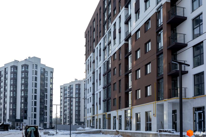 Сучасний житловий комплекс Супернова з коричнево-білими фасадами та балконами. Навколо новобудови видно засніжену територію та будівельні роботи.