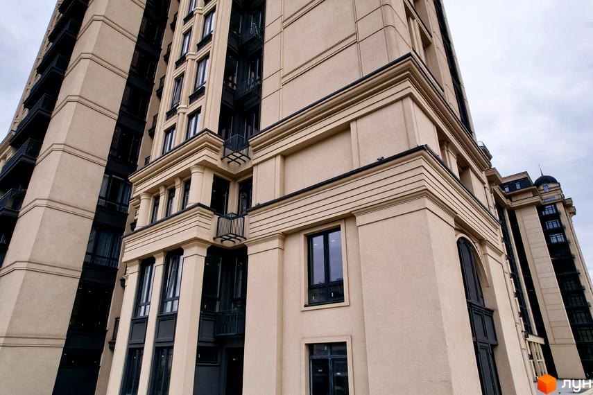 Житловий комплекс Premier Tower. Висотна будівля з бежевими фасадами та чорними вікнами. На фасаді присутні декоративні елементи та балкони.