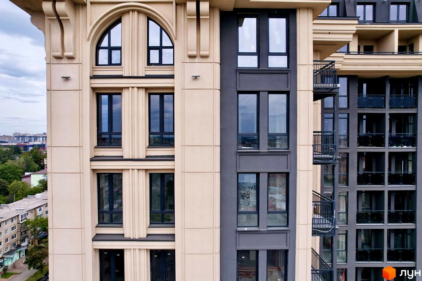 Житловий комплекс Premier Tower з архітектурою у стилі неокласицизму. Бежевий фасад з великими вікнами та балконами, що виходять на місто.