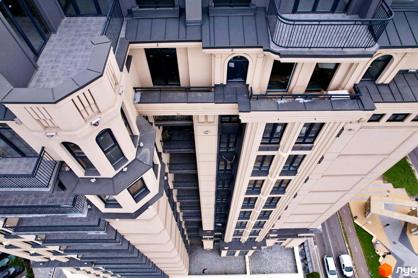 Висотна будівля ЖК Premier Tower з балконами та терасами. Навколо будинку розташована прибудинкова територія з дорогою та парковкою.