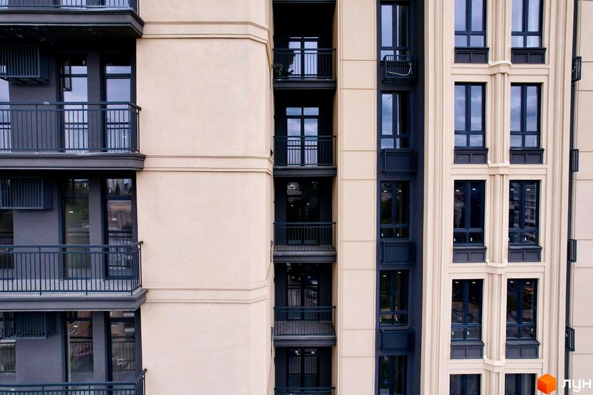 Фасад новобудови Premier Tower з бежевими стінами, темними вікнами та балконами.