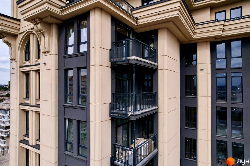 Висотна будівля ЖК Premier Tower з балконами та великими вікнами. Фасад виконано у світлих тонах з темними вставками.