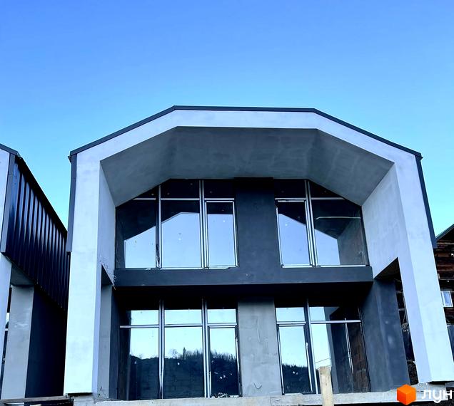 Зовнішній вигляд двоповерхового будинку в Котеджному містечку Black&White Villas з великими вікнами та сірим фасадом.