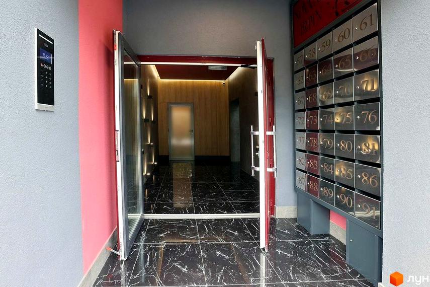 Вхідна група в Житловому комплексі Новатор з поштовими скриньками та домофоном. Вигляд зсередини будинку на вхідні двері.