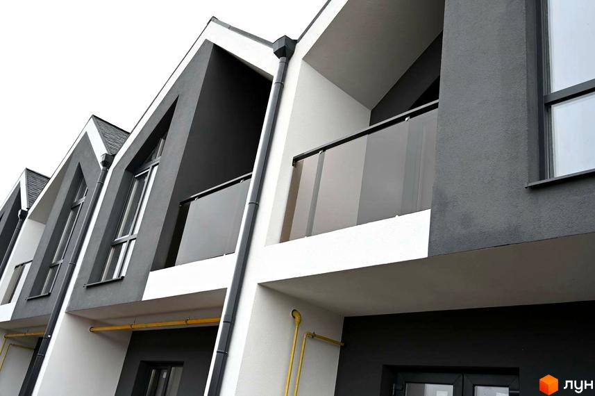 Таунхауси Dream Home з сірим та білим фасадом, великими вікнами та скляними балконами. Зовнішній вигляд новобудови.