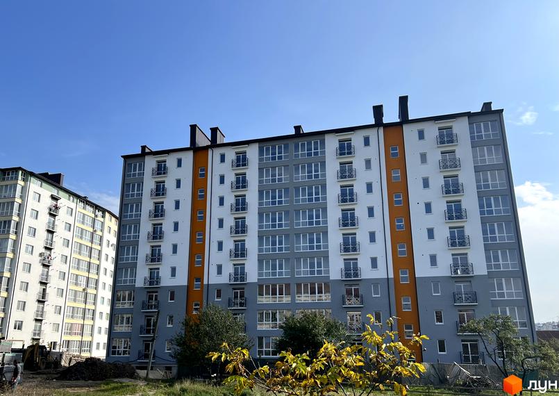 Житловий комплекс Квартал Гімназійний 2 - це сучасна новобудова з яскравим фасадом з білих, сірих та помаранчевих елементів, балконами та великими вікнами. Навколо комплексу зелена територія та дерева.