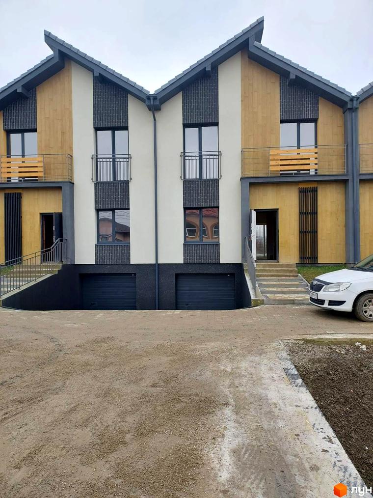 Таунхауси Noble House з багаторівневими фасадами та гаражними воротами. Перед будинками ґрунтова дорога та сходи до входів.