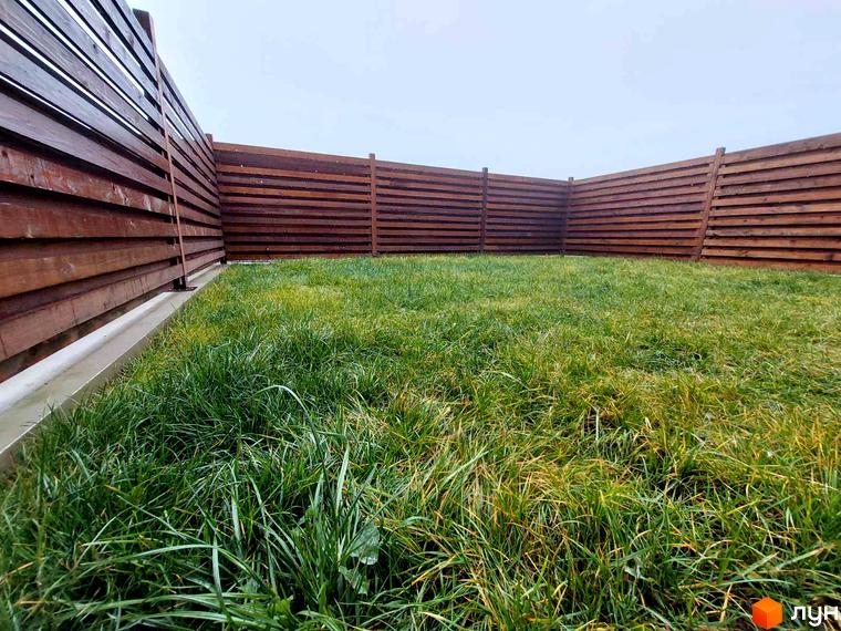 Таунхауси Noble House з дерев'яним парканом та зеленим газоном. Огляд території житлового комплексу.