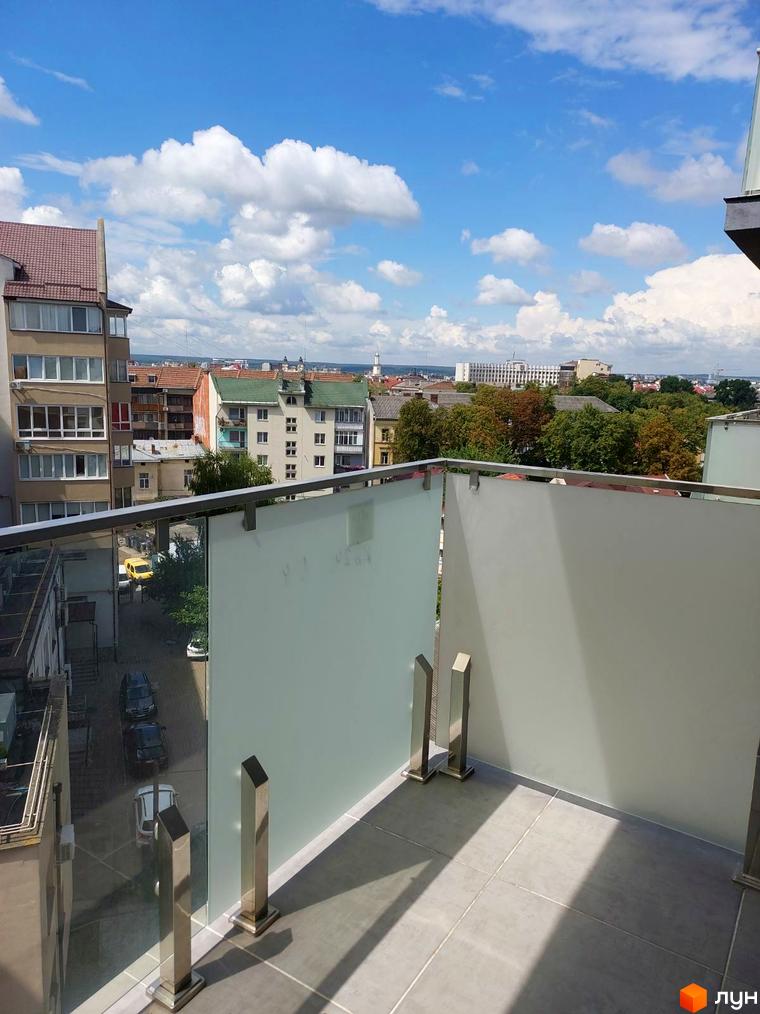 Вид з балкона на вулицю з будинками та машинами. Kovcheg Residence - житловий комплекс з сучасним дизайном.