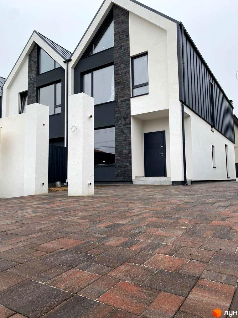 Сучасний житловий комплекс на вулиці Княгині Ольги, 61, з фасадами білого та сірого кольорів, великими вікнами та вимощеною бруківкою прибудинковою територією.