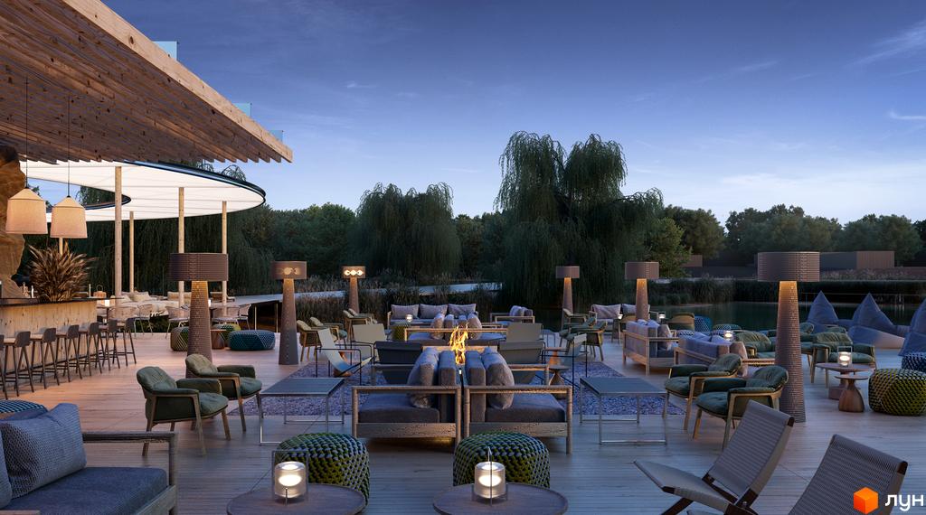 Затишна тераса житлового комплексу Vlasne Misto з каміном та м'якими меблями біля води. Сучасний дизайн зони відпочинку.