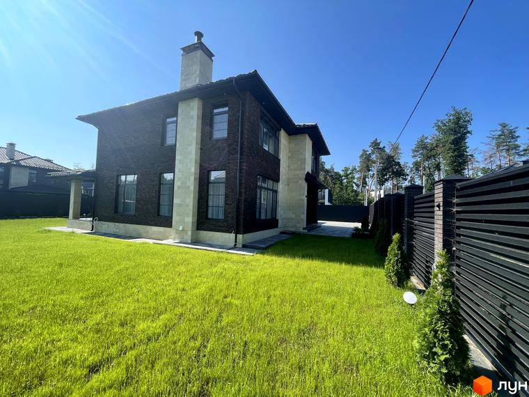 Котеджне містечко Spacious HOME з цегляним фасадом та акуратним газоном. Навколо будинку розташована огорожа та зелені насадження.