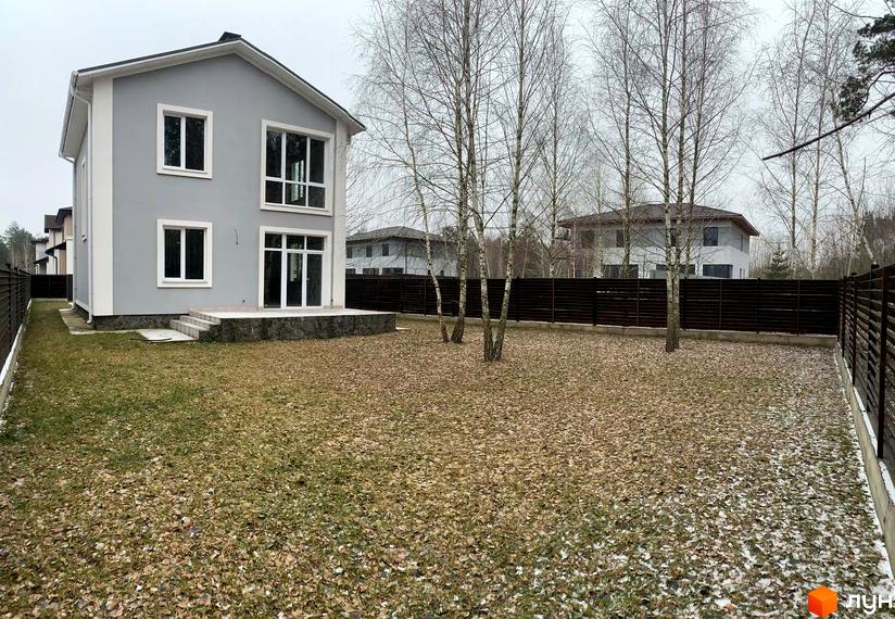 Котеджне містечко ForestK: сірий двоповерховий будинок з великими вікнами та терасою, оточений деревами та огородженою територією.