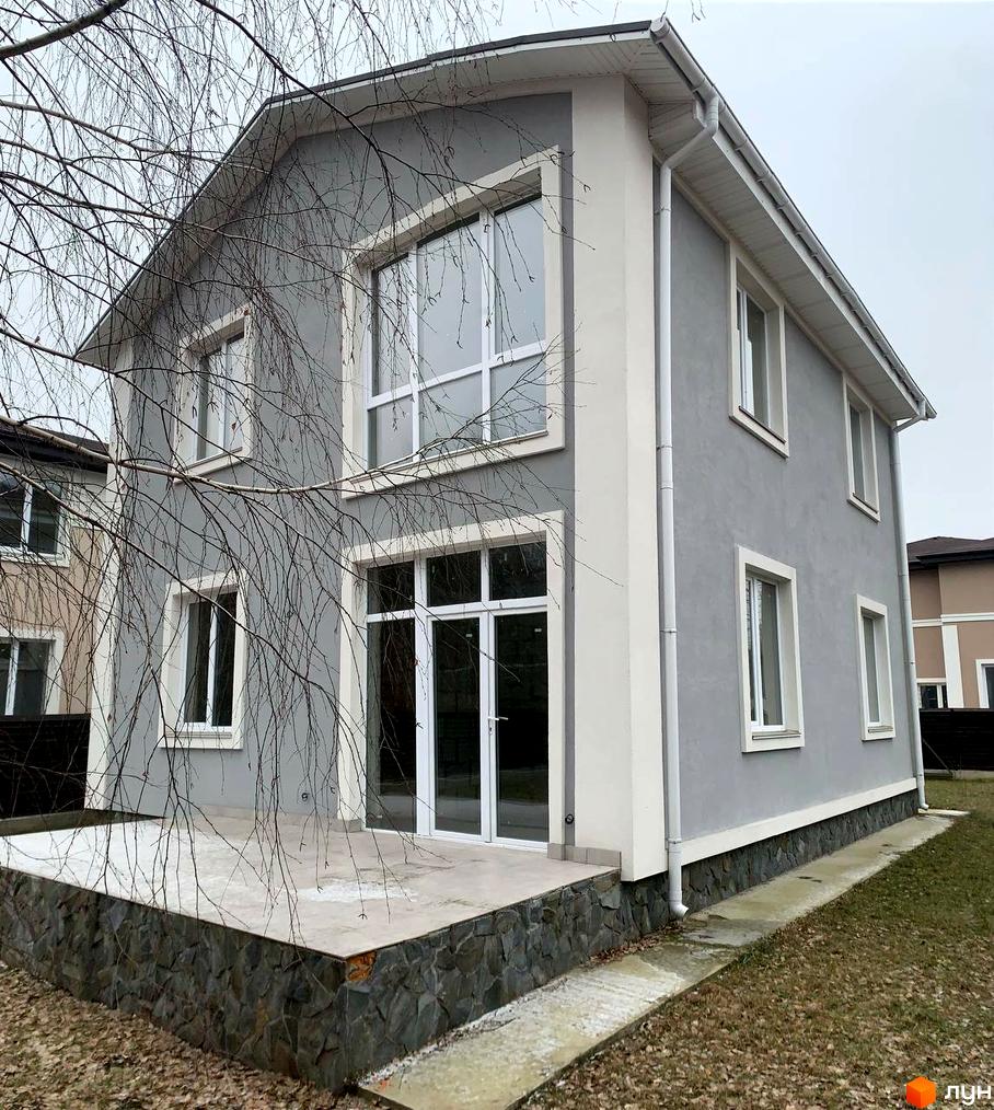 Котеджне містечко KM ForestK: двоповерховий будинок з сірим фасадом та білим оздобленням, кам'яною основою та патіо. Навколо - голі дерева та газон.