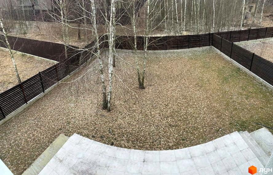 Котеджне містечко ForestK: зелена територія з деревами та огорожею. Вид згори на подвір'я з опалим листям та сходи.