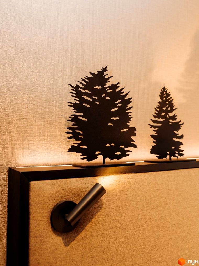 Декоративні силуети ялинок на стіні в апартаментах LEV RESORT HOTEL. Освітлення, що підкреслює деталі інтер'єру.