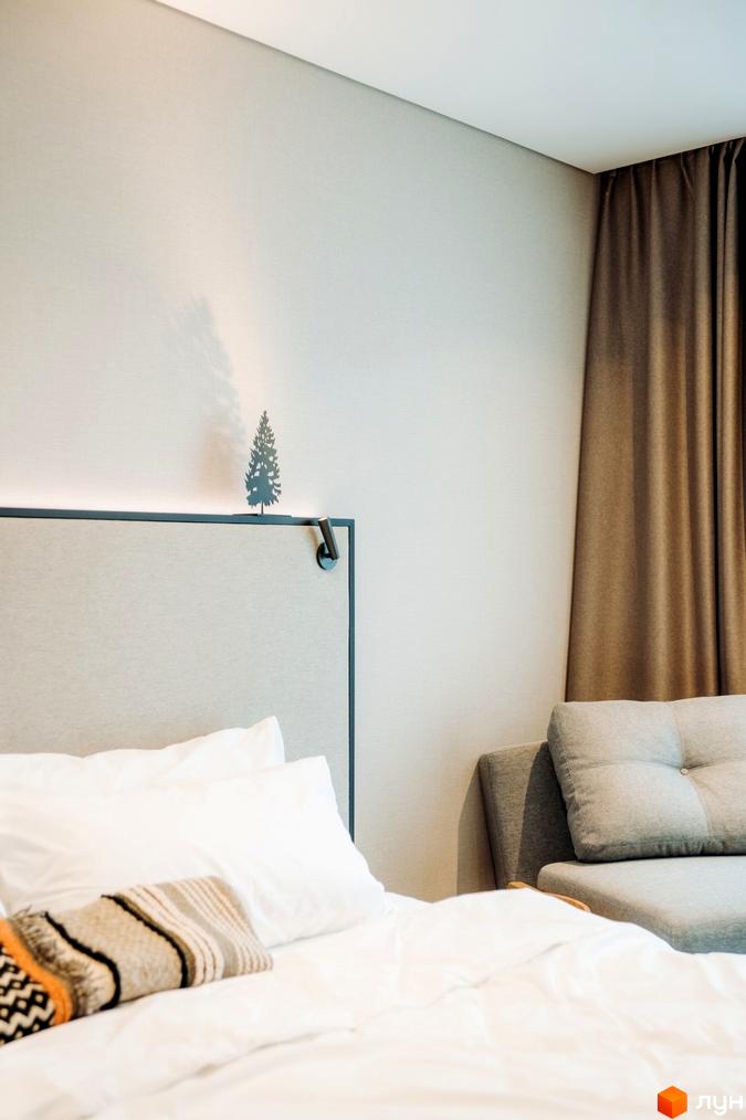 Інтер'єр спальні в апарт-готелі LEV RESORT HOTEL з ліжком, подушками та декоративним елементом у вигляді ялинки.