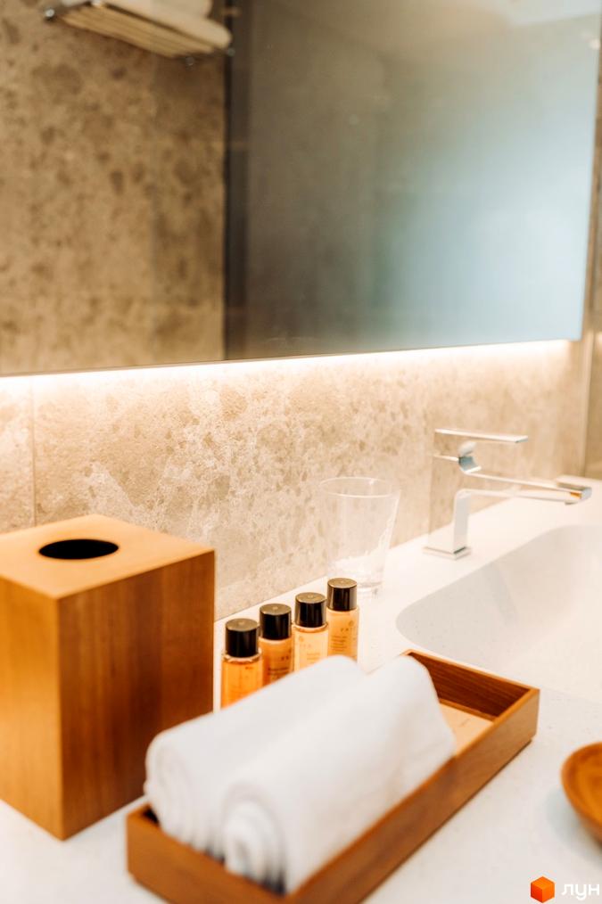 Інтер'єр ванної кімнати в апарт-готелі LEV RESORT HOTEL. На фото видно умивальник, дзеркало, аксесуари для ванної.