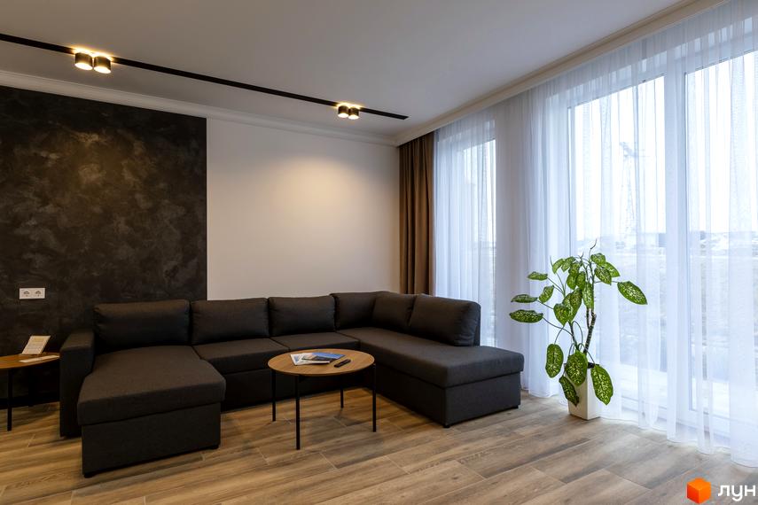 Вітальня з великими вікнами та диваном у ЖК Струмочок 2. Простора кімната з сучасним дизайном та природним освітленням.