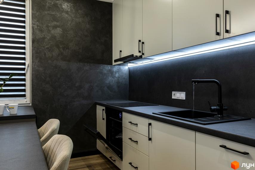 Сучасна кухня з білими фасадами та темно-сірою стільницею. На стіні текстурне покриття з ефектом мармуру.