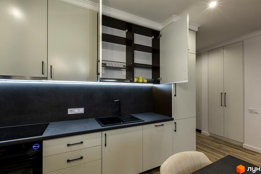 Сучасна кухня з білими фасадами та темною стільницею. Відкриті верхні шафи з полицями та сушаркою для посуду.