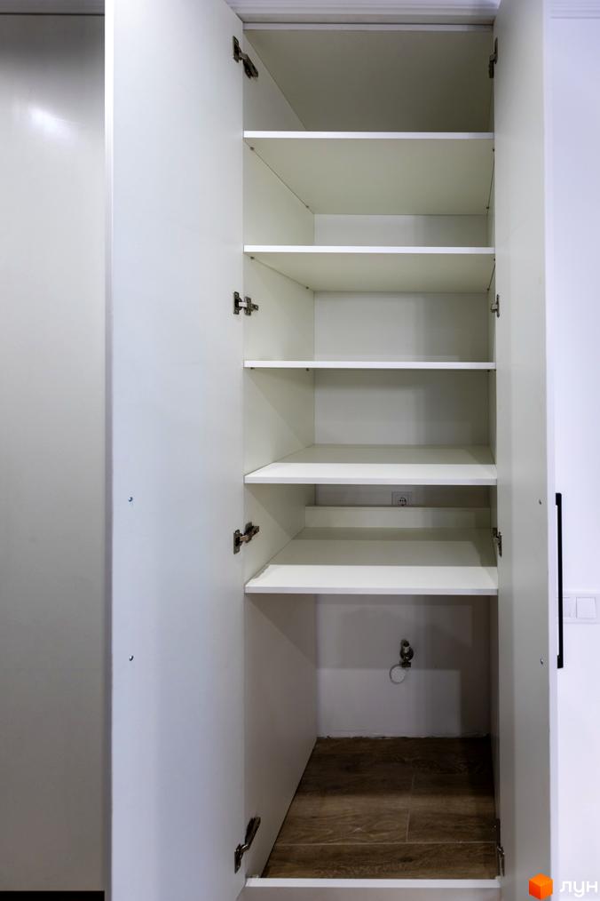 Відкрита шафа з полицями в новобудові ЖК Струмочок 2. Білі двері та полиці, дерев'яна підлога.