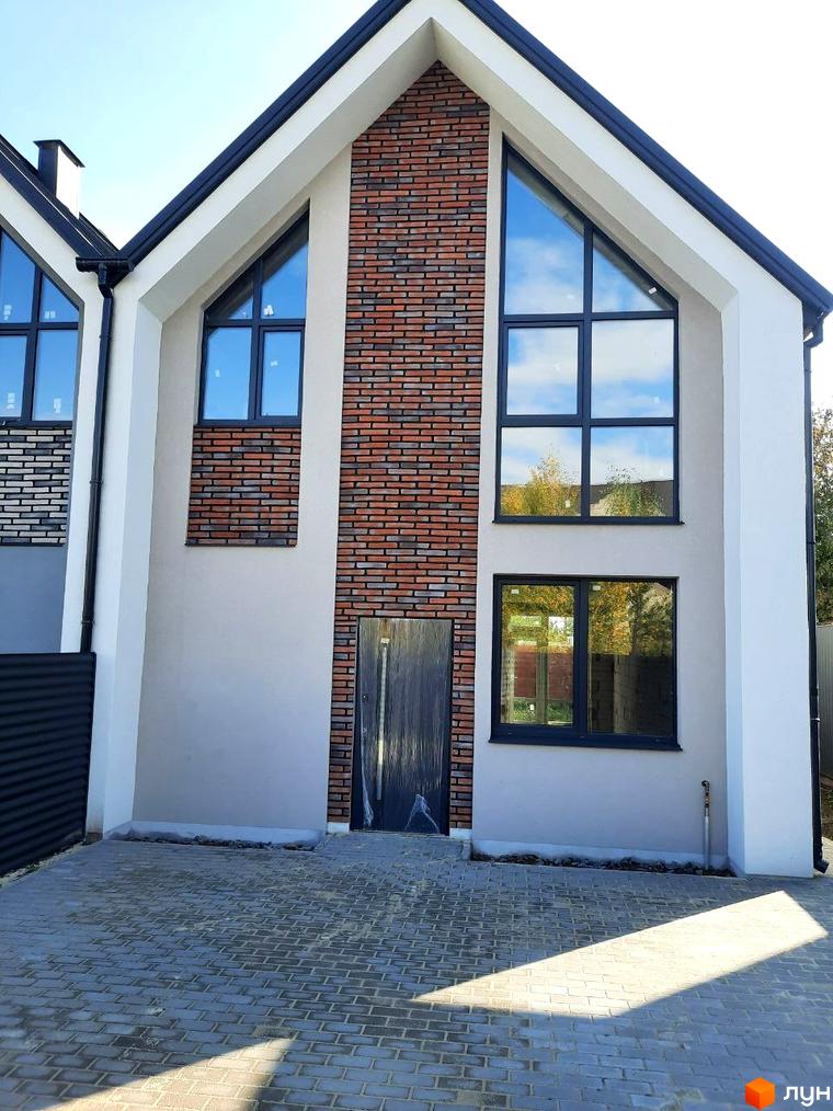 Будинок Котеджного містечка Villa Gatne 2 має світлий фасад, центральну цегляну вставку та великі вікна. Перед будинком викладений бруківкою двір.